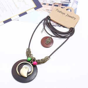 Bohemian multi-layer long necklace with wooden ring and bronze bird pendant on white background