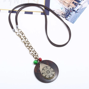 Collana vintage con disco in legno e ciondolo floreale in bronzo su cordino