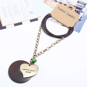 Vintage heart pendant necklace with green bead and wooden disc on leather rope