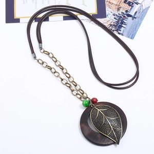 Vintage long necklace with bronze alloy leaf and wooden ring pendant on wax cord
