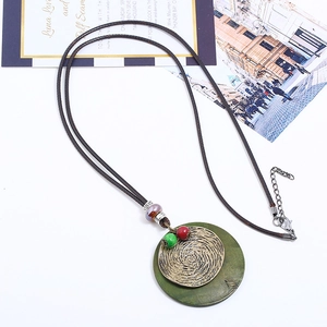 Retro ethnic long necklace with brass spiral pendant and green wood base on wax cord