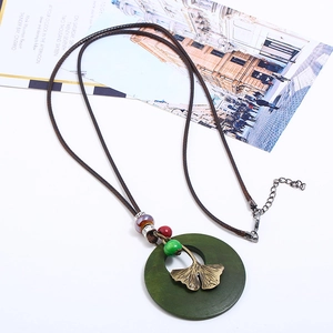 Collier multicouche vintage feuille de ginkgo avec perles colorées sur fond blanc