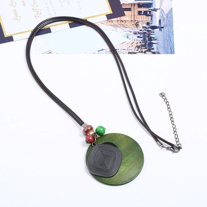 Sautoir artistique avec pendentif en bois vert et métal ciselé sur cordon marron