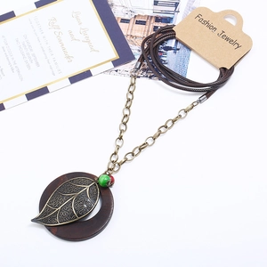 Retro long necklace with wooden pendant, golden leaf, and red-green beads on wax cord