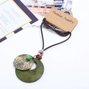 Retro ethnic style long necklace with green wooden ring and antique bronze pendant on wax cord