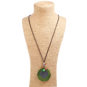 Sautoir ethnique en cordon de cire avec pendentif en alliage vert et gris sur un mannequin