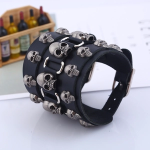 Wide punk leather bracelet with silver skull charms and adjustable metal buckle