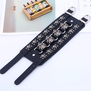 Detailed macro view of black punk leather bracelet with silver skull rivets and buckles