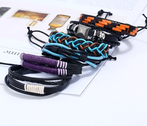 Gros plan d'un ensemble de 6 bracelets en cuir multicouches avec cordes tissées et métaux