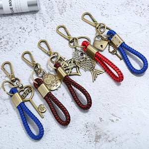 Detail of vintage braided leather keychains with bronze charms like heart keys and owls