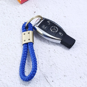 Blue braided leather keychain with gold metal buckle attached to a car key