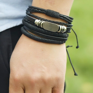 Detailansicht von mehrlagigen Lederarmbändern mit Metallelementen am Handgelenk