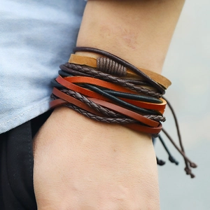Close-up of layered vintage braided leather bracelets with mixed textures on wrist