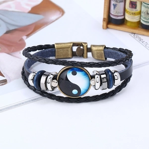 Detail of multi-layer woven leather bracelet featuring Yin Yang charm and buckle closure