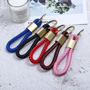 Close-up of woven leather keychains in multiple colors with vintage gold rings