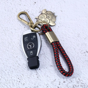 Detail of woven leather keychain with bronze owl charm and car key remote protector