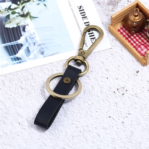 Vintage industrial style black leather keychain with bronze metal clasp and ring detail