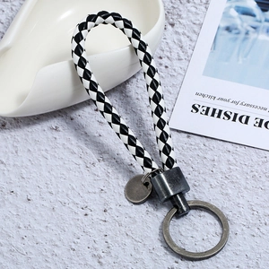 Detail of hand-woven checkerboard leather keychain with vintage finish metal ring
