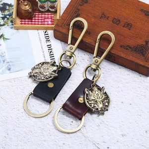 Vintage bronze wolf head leather keychains in black and brown on a white surface