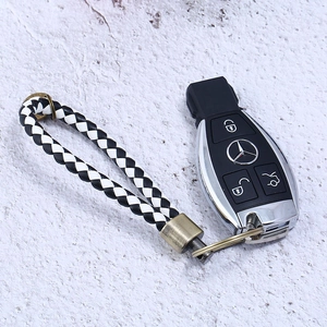 Close-up of black and white braided leather keychain with vintage bronze hardware detail