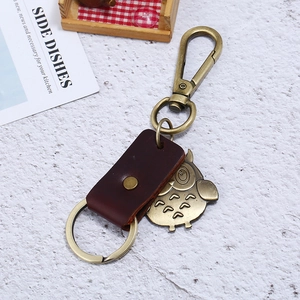 Vintage owl keychain featuring brown leather strap and antique brass metal pendant detail