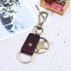 Vintage leather eagle keychain with bronze alloy star pendant on a white background