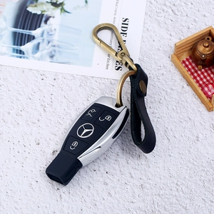 Detailed view of bronze metal buckle and leather strap on a black car key protector
