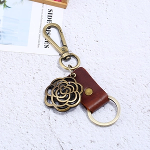 Retro bronze camellia pendant leather keychain for men with vintage finish on stone base