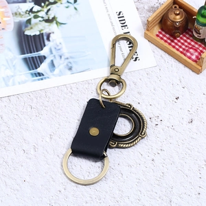 Vintage bronze alloy keychain with black leather strap and embossed circular pendant