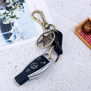 Detail of vintage bronze star pendant on genuine leather keychain with spring hook