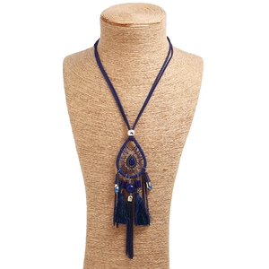 Detail of bohemian dreamcatcher pendant with blue beads and long silk tassels