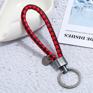 Detail of red and black braided PU leather keychain with brushed grey metal hardware