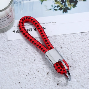 Detail of red and black braided leather keychain with polished silver metal ring