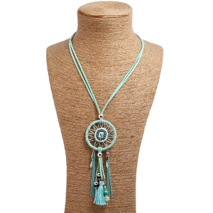Bohemian dreamcatcher long necklace with turquoise beads and silk tassels on mannequin