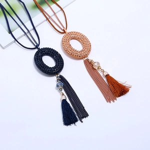 Dettaglio della collana in lega con ciondolo ovale di strass e nappe di seta elegante