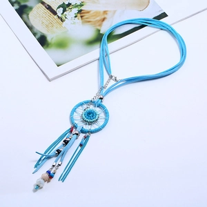 Detail of bohemian dreamcatcher necklace with sky blue beads and tassel on white background