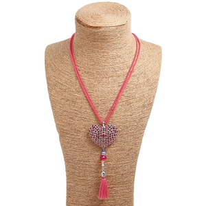 Detail of pink tassel sweater necklace with sparkling rhinestone heart pendant