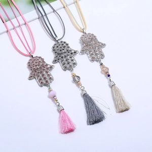 Detailed view of alloy Hamsa Hand pendants with rhinestones and colorful silk tassels