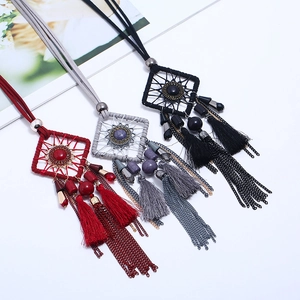 Détail d'un collier pendentif attrape-rêves bohème avec pierres et glands colorés