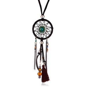Detail of bohemian dreamcatcher necklace featuring a green gemstone and colorful beads