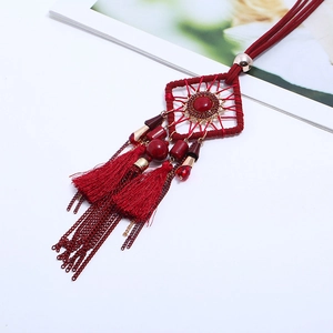 Collier attrape-rêves rouge de style ethnique avec pierre en résine et pompons sur fond blanc