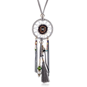 Detailed view of bohemian dreamcatcher pendant with grey silk tassels and gemstone