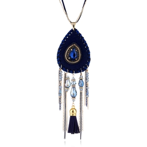 Dettaglio collana boho con cristallo blu a goccia e nappina in pelle scamosciata blu