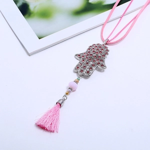 Silver Hamsa Hand necklace with pink rhinestones and silk tassel on a white surface