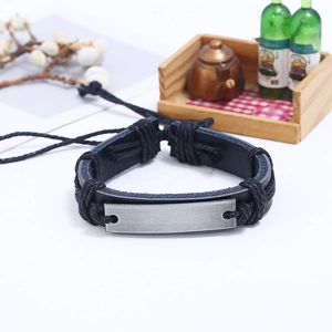 Close-up of men's layered leather bracelet with a gray brushed metal plaque and woven rope