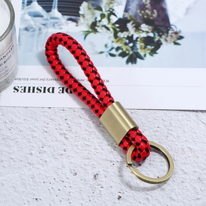 Close-up of red and black braided leather keychain with vintage bronze metal ring