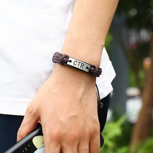 Men's vintage braided leather bracelet with CTR engraved metal plate on a male wrist
