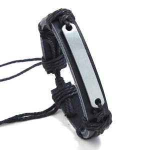 Détail d'un bracelet ajustable en cuir tressé avec plaque métallique gravable pour homme