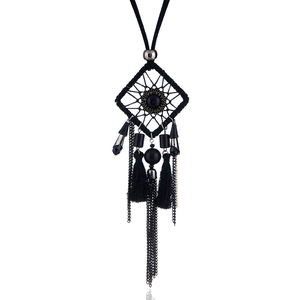 Détail macro du pendentif attrape-rêve avec glands en soie noire et fines chaînes en métal