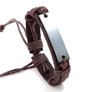 Detail view of a vintage multi-layer braided leather bracelet with matte metal plate